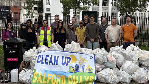 Litter pickers with all the bags at the end of the litter pick behind the clean up salford quays banner